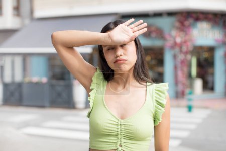 Photo for Pretty hispanic woman looking stressed, tired and frustrated, drying sweat off forehead, feeling hopeless and exhausted - Royalty Free Image