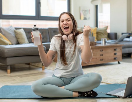 Foto de Joven bonita mujer sintiéndose sorprendida, riendo y celebrando el éxito. concepto de yoga - Imagen libre de derechos