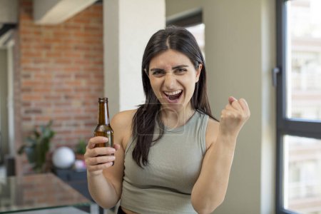 Téléchargez les photos : Jeune femme à l'air en colère, agacé et frustré. bouteille de bière - en image libre de droit