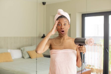 Foto de Negro afro mujer buscando feliz, asombrado y sorprendido. concepto de secador de pelo - Imagen libre de derechos