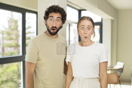 Foto de Joven pareja adulta buscando muy sorprendido o sorprendido, mirando con la boca abierta diciendo wow - Imagen libre de derechos