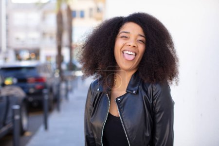 Téléchargez les photos : Afro-américaine jolie femme avec gaie, insouciante, attitude rebelle, plaisanter et sortir la langue, s'amuser - en image libre de droit