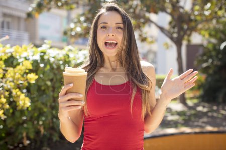 Téléchargez les photos : Pretty woman feeling happy and astonished at something unbelievable. take away coffee concept - en image libre de droit