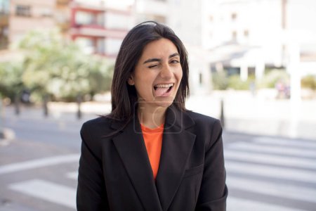 Foto de Bonita mujer con actitud alegre, despreocupada, rebelde, bromeando y sacando la lengua, divirtiéndose - Imagen libre de derechos