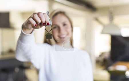 Foto de Joven adulto bonita mujer rubia con una nueva llave del hogar. concepto de bienes raíces - Imagen libre de derechos