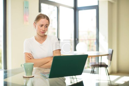 Foto de Mujer guapa caucásica con un ordenador portátil sentirse disgustado y decepcionado, mirando serio, molesto y enojado con los brazos cruzados - Imagen libre de derechos
