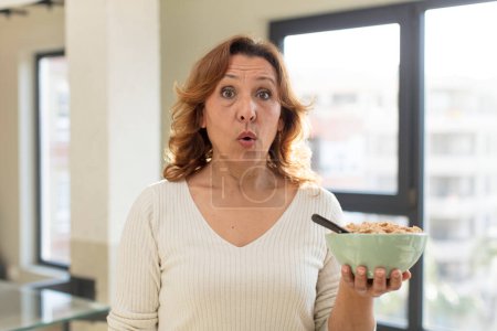 Foto de Mujer bonita de mediana edad se siente muy sorprendido y sorprendido. concepto de plato de desayuno - Imagen libre de derechos