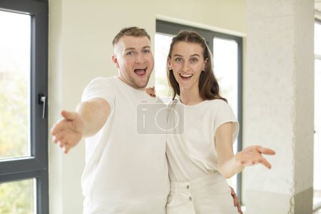Téléchargez les photos : Sourire heureux et offrir ou montrer un concept. concept de jeune couple - en image libre de droit