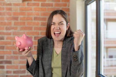 Photo for Young pretty woman looking angry, annoyed and frustrated. piggy bank concept - Royalty Free Image