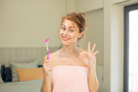 Photo for Young pretty woman feeling happy, showing approval with okay gesture.  mouthwash concept - Royalty Free Image