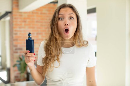 Photo for Pretty woman feeling extremely shocked and surprised. vaper concept - Royalty Free Image