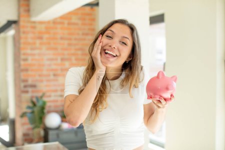 Photo for Pretty woman feeling happy and astonished at something unbelievable. piggy bank concept - Royalty Free Image