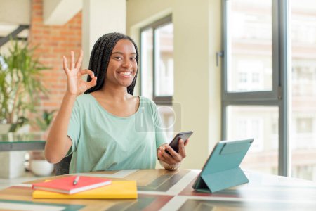 Téléchargez les photos : Femme afro noire se sentant heureuse, montrant son approbation avec un geste correct. étude du concept - en image libre de droit