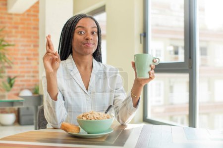 Foto de Mujer afro negro cruzando los dedos y esperando buena suerte. concepto de desayuno - Imagen libre de derechos