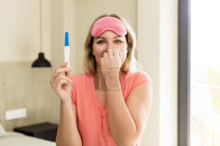Photo for Pretty young woman with a pregnancy test. house interior design - Royalty Free Image