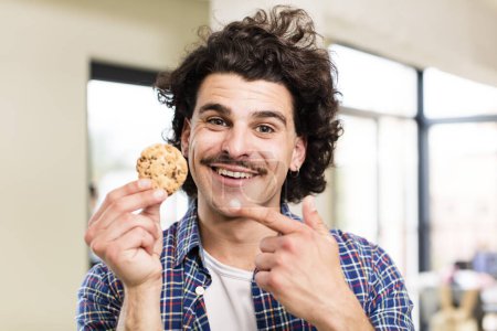 Photo for Young handsome man with a homemade cookie at home interior - Royalty Free Image
