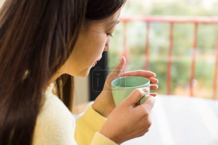 Téléchargez les photos : Asian pretty woman with a coffee cup at cool home - en image libre de droit