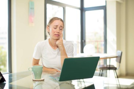 Photo for Caucasian pretty woman with a laptop looking desperate and frustrated, sad, unhappy and crying - Royalty Free Image
