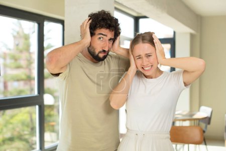 Photo for Young adult couple feeling stressed, worried, anxious or scared, with hands on head, panicking at mistake - Royalty Free Image