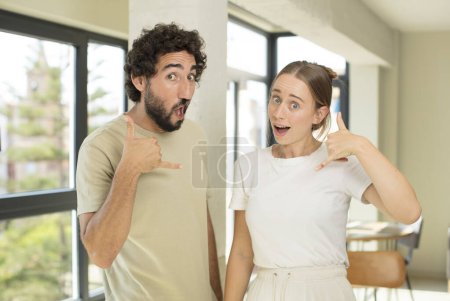 Photo for Young adult couple crazy happily and cheerfully, waving hand, welcoming and greeting you, or saying goodbye - Royalty Free Image
