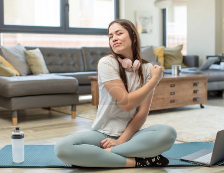 Téléchargez les photos : Jeune femme adulte pratiquant le yoga se sentant heureuse, positive et réussie, concept d'argent et célébrer de bons résultats - en image libre de droit