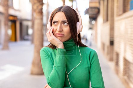 Photo for Feeling bored, frustrated and sleepy after a tiresome. listening music with headphones - Royalty Free Image