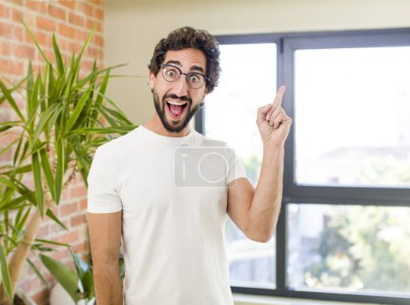 Foto de Young adult crazy man with expressive pose at a modern house interior - Imagen libre de derechos