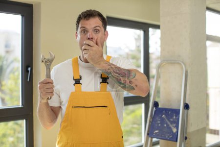 Photo for Covering mouth with a hand and shocked or surprised expression. repairman concept - Royalty Free Image