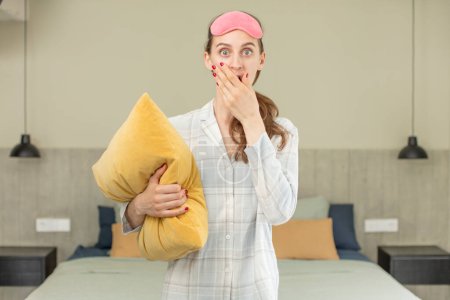 Photo for Covering mouth with a hand and shocked or surprised expression. pajamas or night wear concept - Royalty Free Image