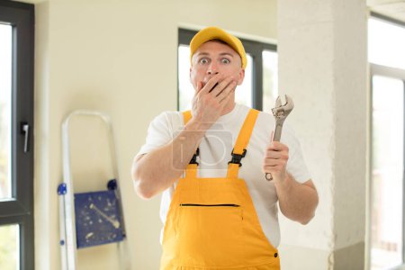 Photo for Covering mouth with a hand and shocked or surprised expression. handyman concept - Royalty Free Image