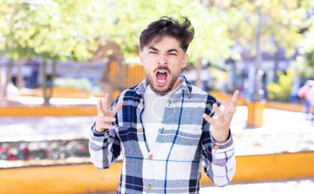Photo for Young handsome man looking angry, annoyed and frustrated screaming wtf or whats wrong with you - Royalty Free Image