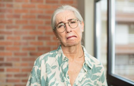 Téléchargez les photos : Senior jolie femme se sent triste et pleurnichard avec un regard malheureux, pleurer avec une attitude négative et frustrée - en image libre de droit