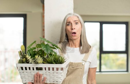 Photo for Pretty senior woman feeling extremely shocked and surprised. gardener concept - Royalty Free Image
