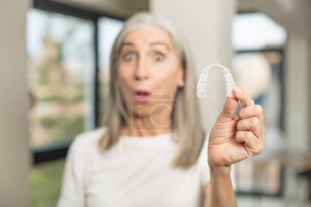 Photo for Pretty senior woman feeling extremely shocked and surprised. with a dental retainer - Royalty Free Image