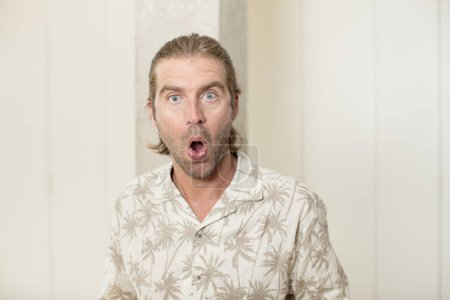 Photo for Young blond adult man looking very shocked or surprised, staring with open mouth saying wow - Royalty Free Image