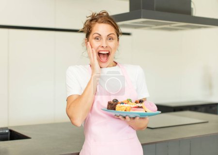 Photo for Young pretty woman feeling happy and astonished at something unbelievable. home made cakes concept - Royalty Free Image