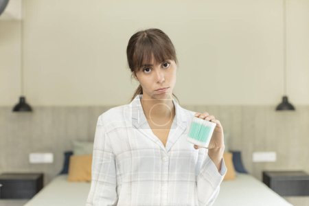 Photo for Young pretty woman feeling sad and whiney with an unhappy look and crying ear bud concept - Royalty Free Image
