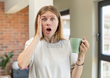 Photo for Young pretty woman feeling extremely shocked and surprised. coffee cup concept - Royalty Free Image