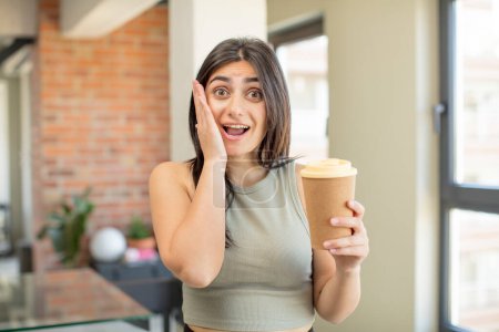Téléchargez les photos : Jeune femme se sentant heureuse et étonnée de quelque chose d'incroyable. emporter café - en image libre de droit