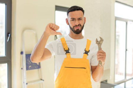 Photo for Arab handsome man arab man feeling cross,showing thumbs down. handyman with a wrench - Royalty Free Image