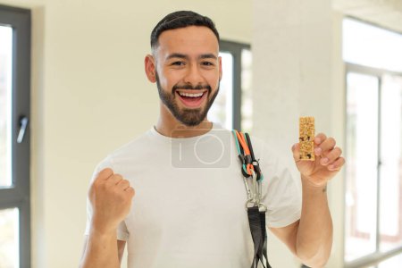 Foto de Árabe hombre guapo árabe hombre sentirse sorprendido, riendo y celebrando el éxito. concepto de barra de cereales y fitness - Imagen libre de derechos