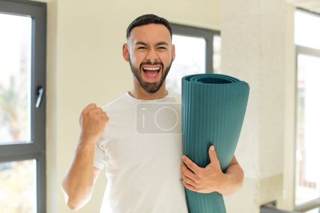 Téléchargez les photos : Arabe bel homme arabe homme se sentant choqué, riant et célébrant le succès. yoga concept mat - en image libre de droit