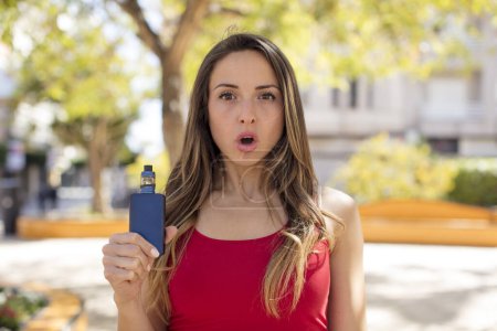 Photo for Pretty woman feeling extremely shocked and surprised. vaper concept - Royalty Free Image