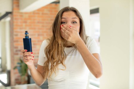 Photo for Pretty woman covering mouth with a hand and shocked or surprised expression. vaper concept - Royalty Free Image
