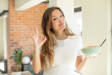 Foto de Bonita mujer sintiéndose feliz, mostrando aprobación con buen gesto. concepto de plato de desayuno - Imagen libre de derechos