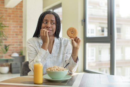 Photo for Black afro woman feeling scared, worried or angry and looking to the side. breakfast concept - Royalty Free Image