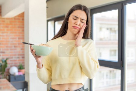 Photo for Pretty young model feeling bored, frustrated and sleepy after a tiresome. breakfast bowl concept - Royalty Free Image