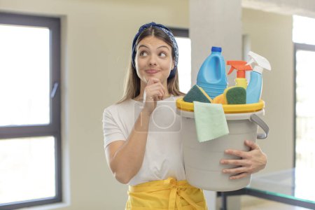Photo for Young pretty woman smiling with a happy, confident expression with hand on chin. clean products and housekeeping concept - Royalty Free Image