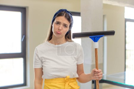 Photo for Young pretty woman feeling sad and whiney with an unhappy look and crying. windows washer concept - Royalty Free Image