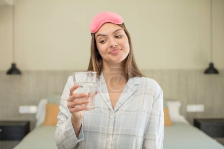 Photo for Young pretty woman smiling and looking with a happy confident expression. water glass concept - Royalty Free Image